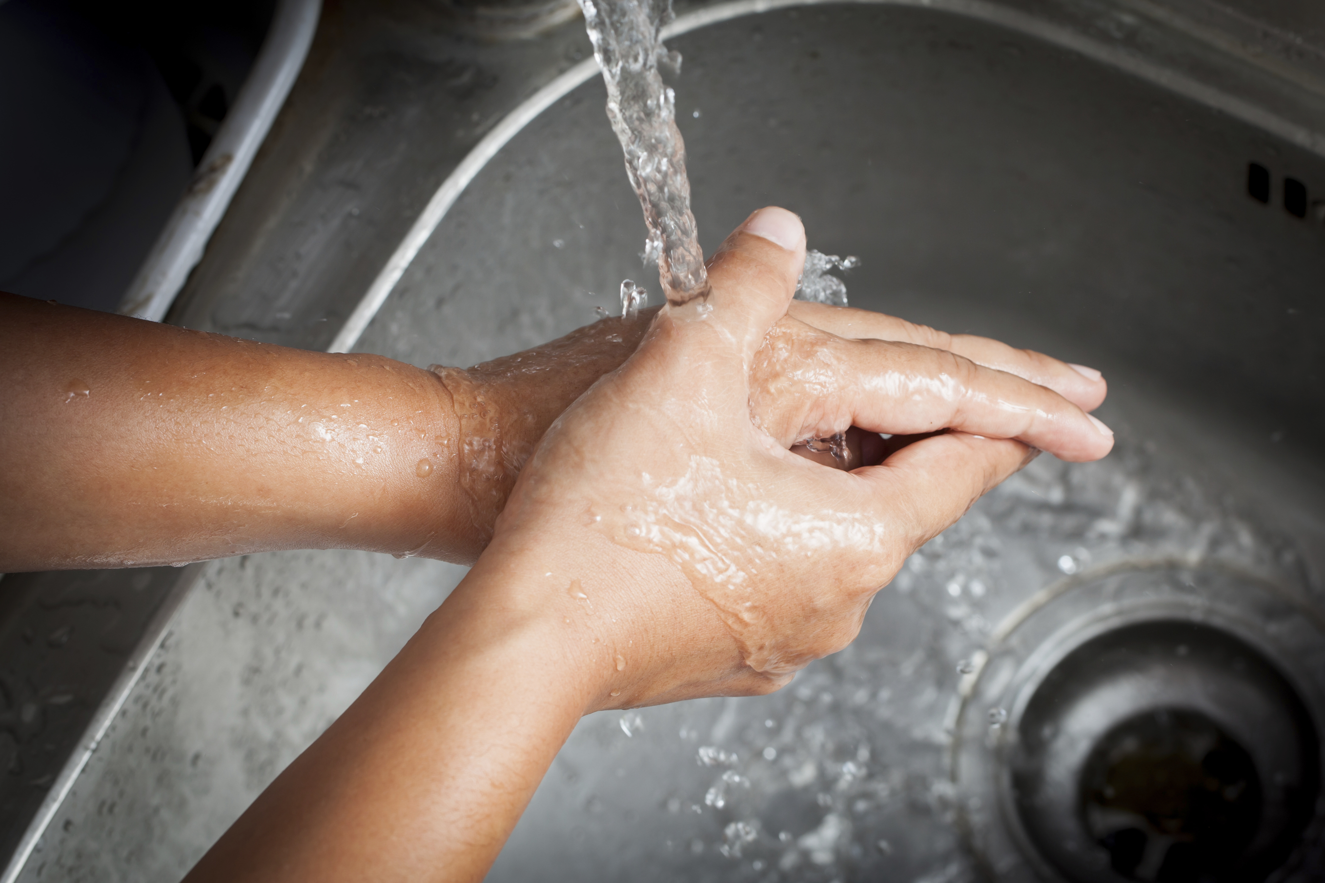 Woman washing her hands under running water